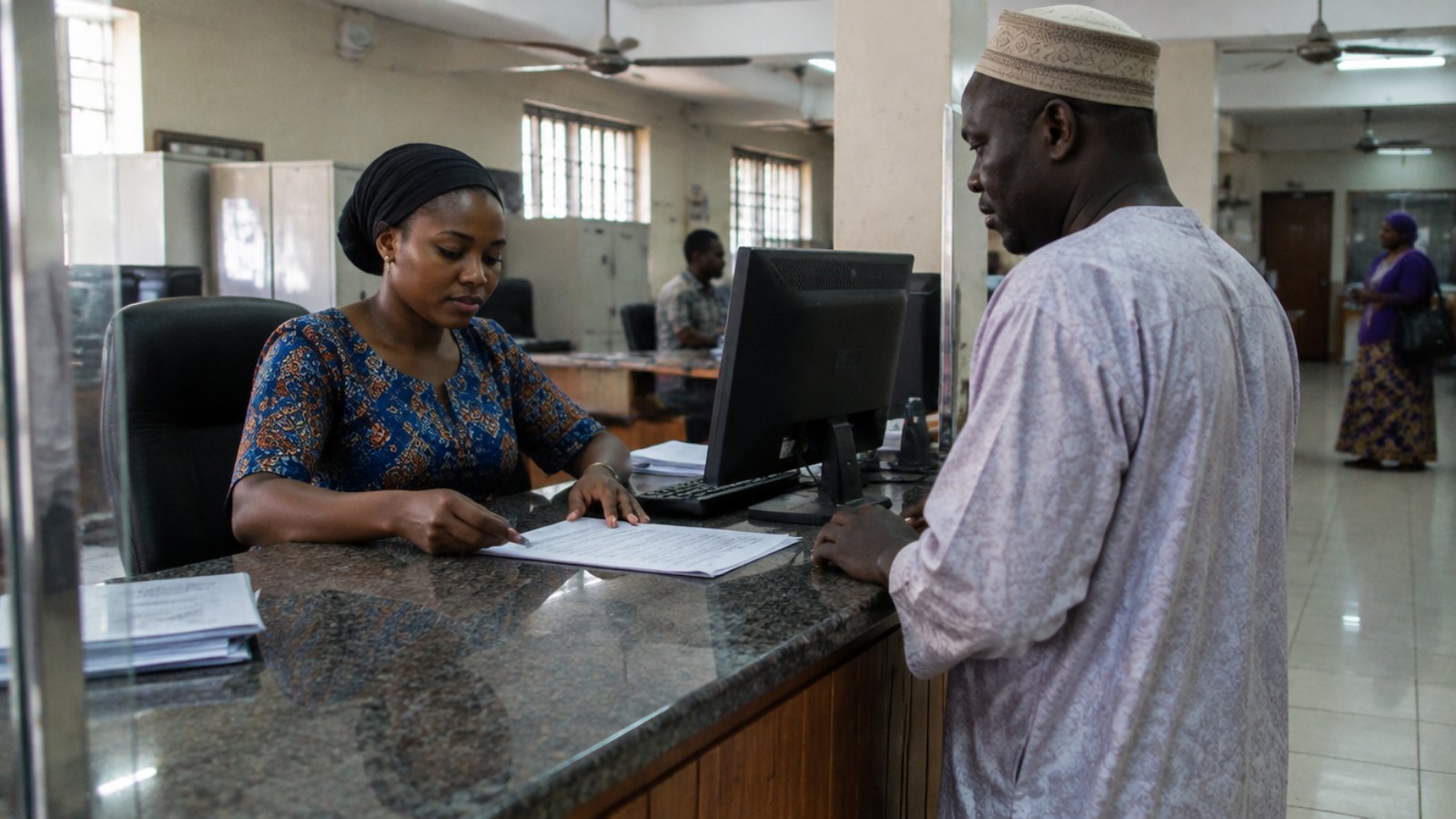 Bankangestellter in einer Filiale in Serrekunda, Gambia, bedient einen Kunden
