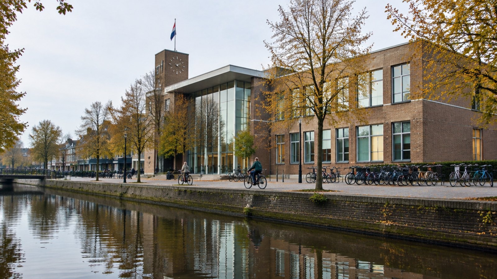 Dutch town hall beside a canal with parked bicycles