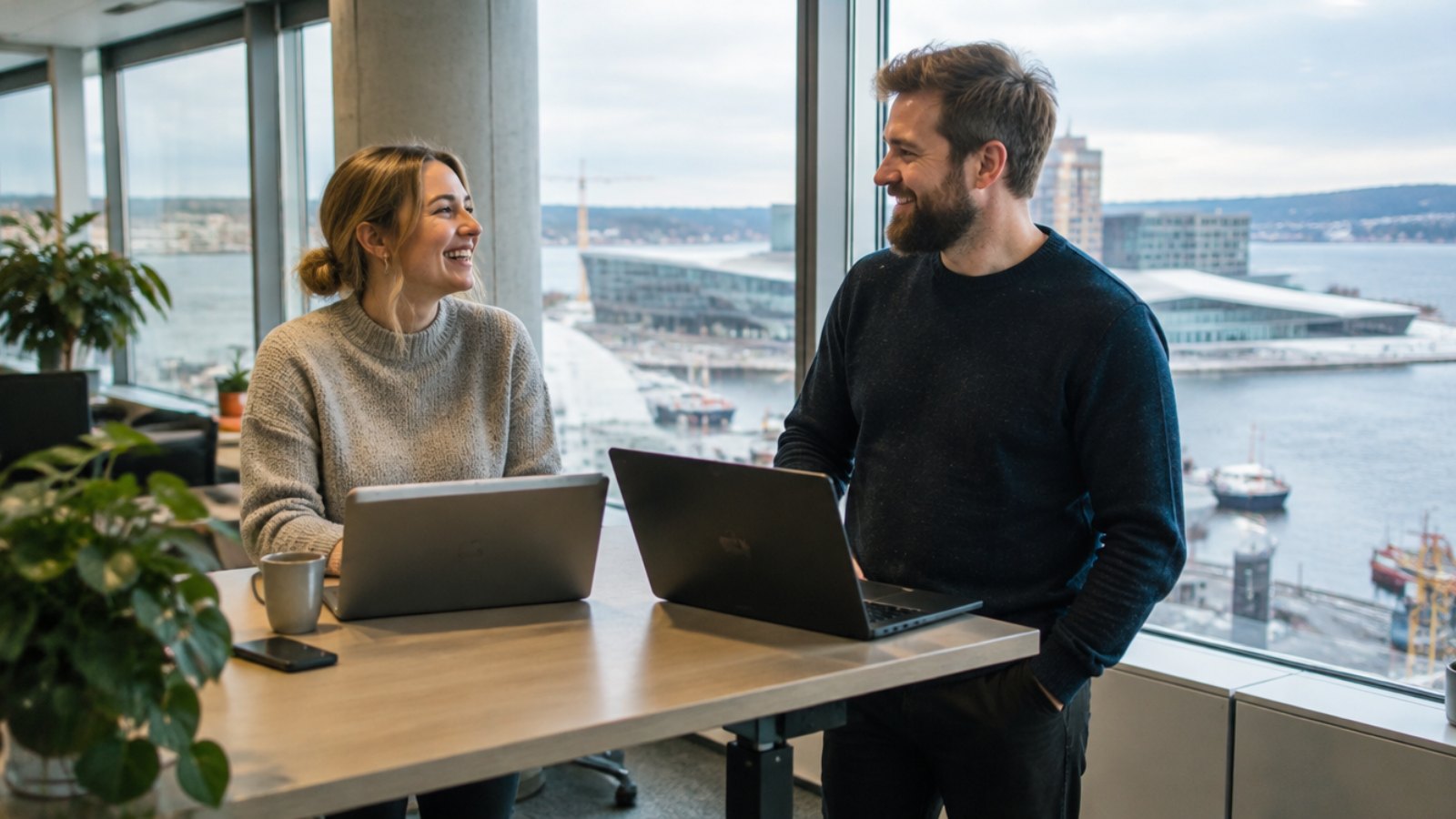 Colleagues talking in a bright office in Oslo with a view of the fjord